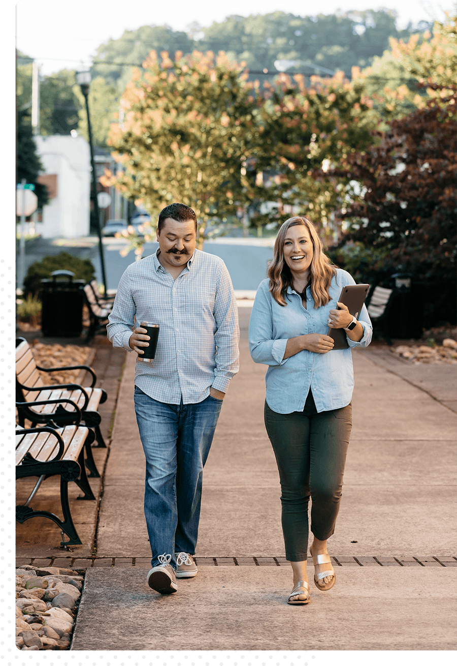 Two coworkers chatting and walking downtown.