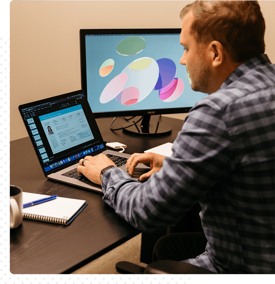 A man working on his laptop at a desk.