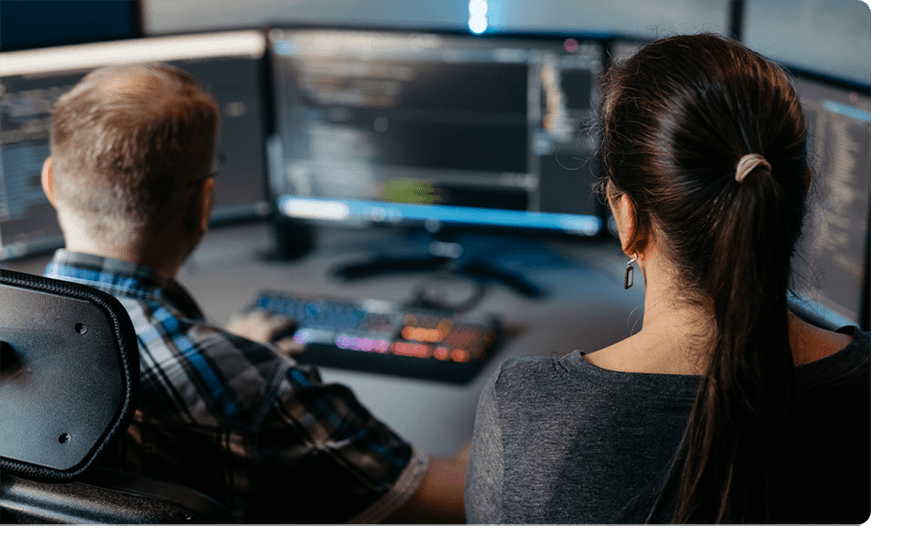 A woman looking over the shoulder of a male developer.