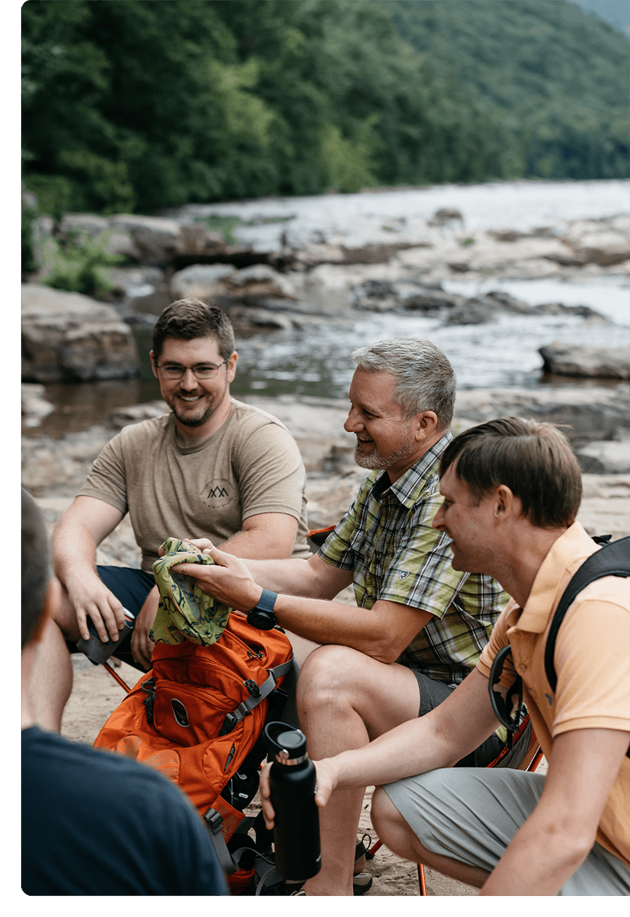 Three men hanging together outside on a camping trip