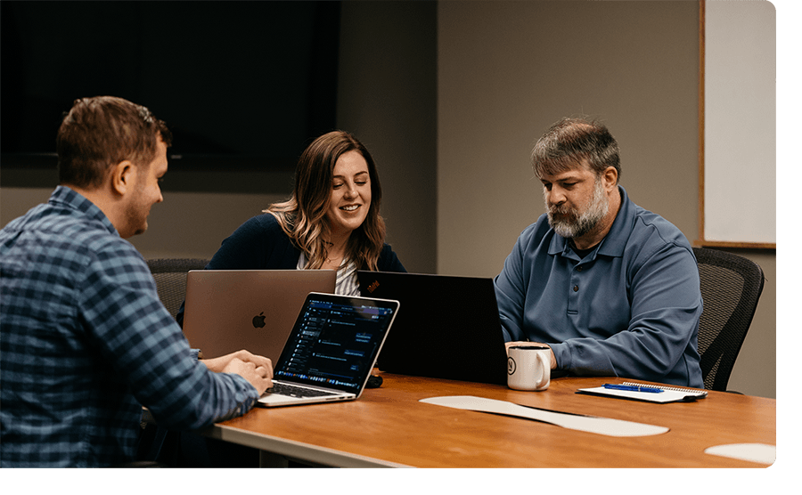 Two men and a woman work together in a meeting at Ntara.