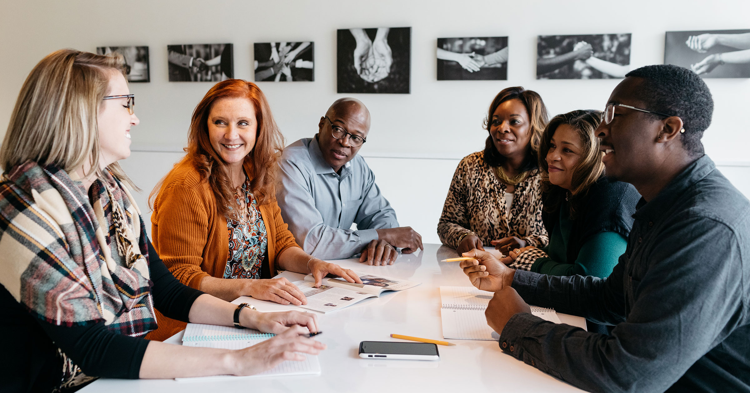 Four people working together at a white table.