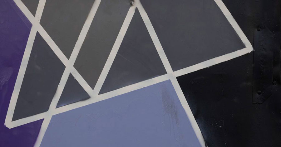Gray, blue and black angles with white trim painted on a wall.