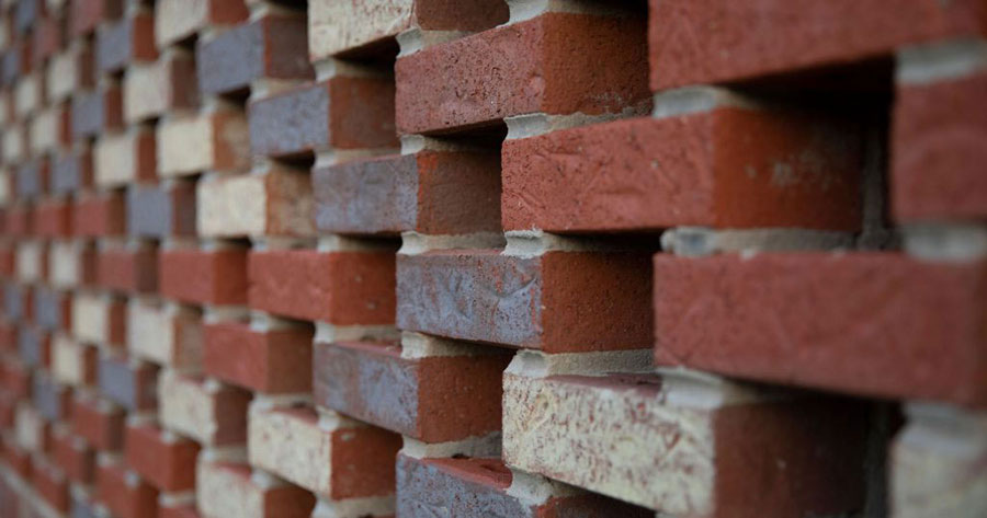 A right-angled view of brick stacked in an alternating and open grid pattern.