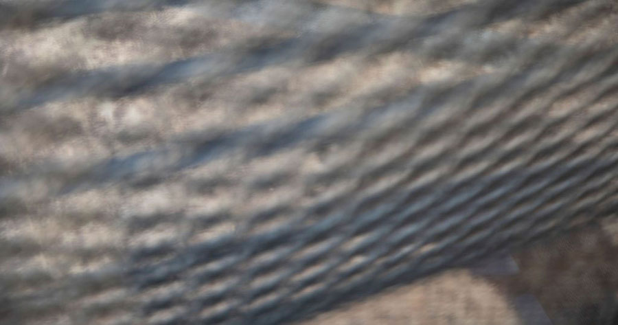 A blurry abstract view of a metal wire fence.