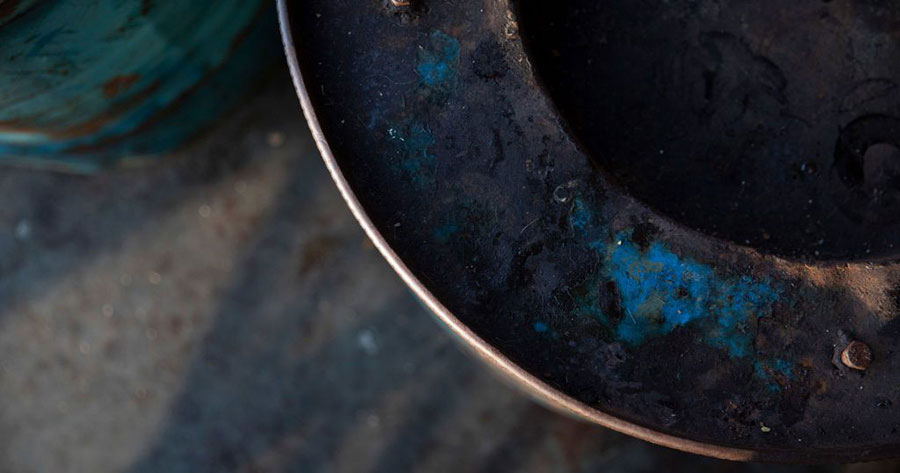 An abstract image of a rusted blue metal, curved structure.