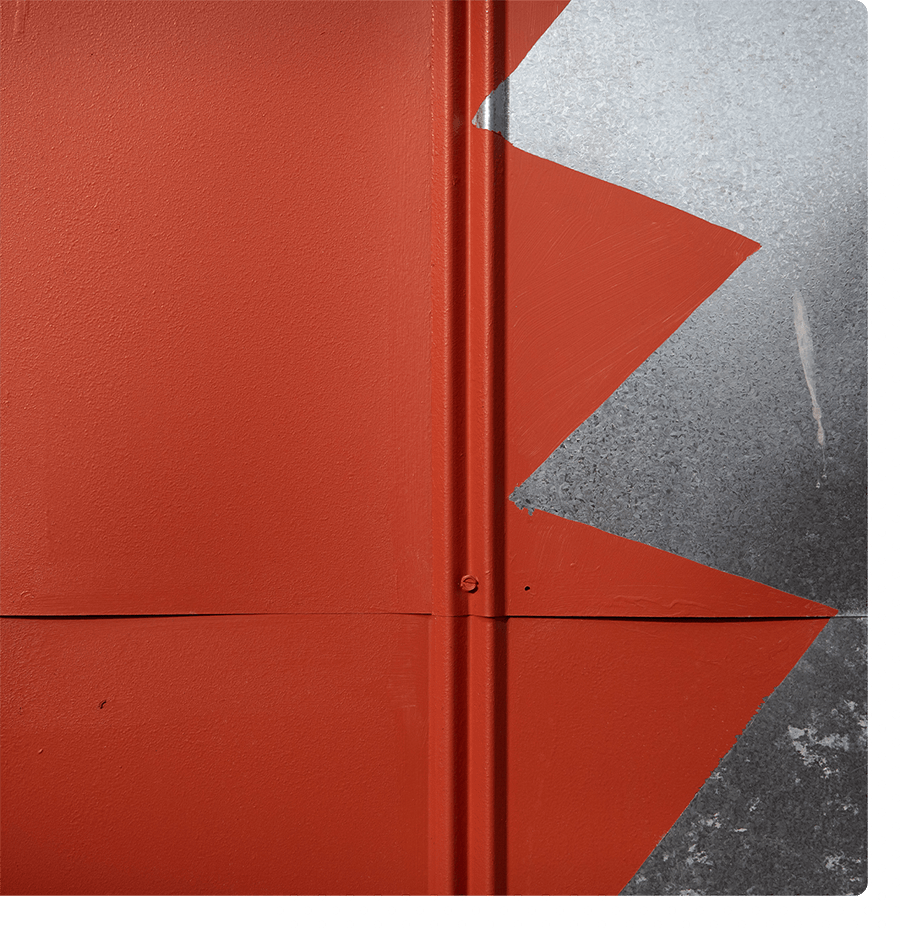 An abstract close-up of a red wall with a silver zig zag pattern on the right.