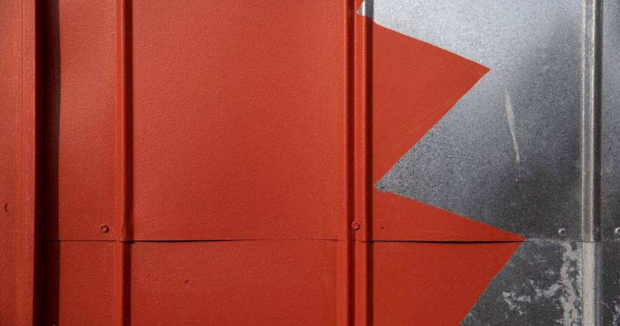 A close up image of an orange wall with a silver zig zag down it.