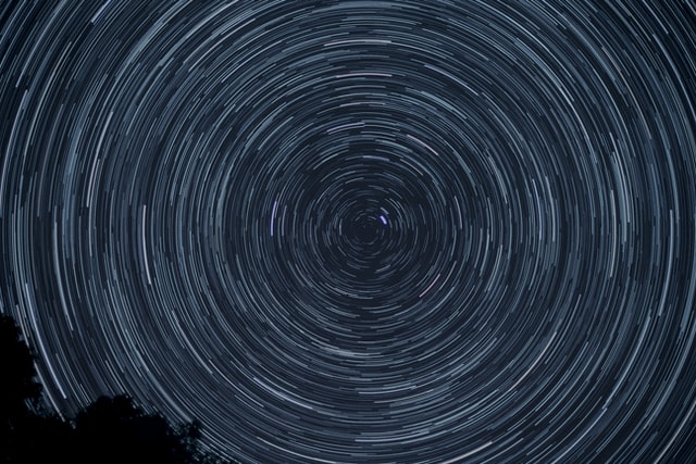 An image of the starry sky that has been swirled together creating circular lines across the sky.