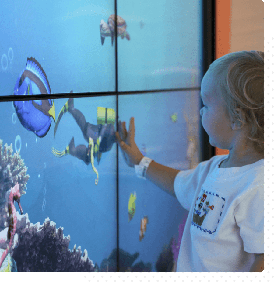 A child touches an interactive digital wall at Vidant Children's Hospital.