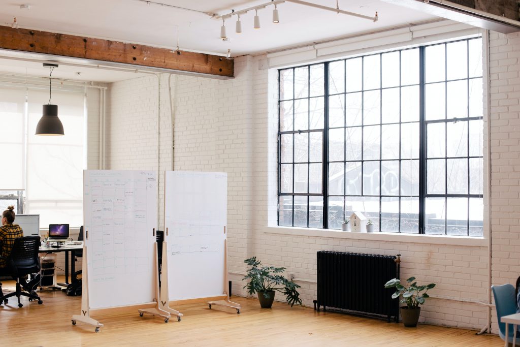 A light filled office space with two whiteboards setup for a workshop.