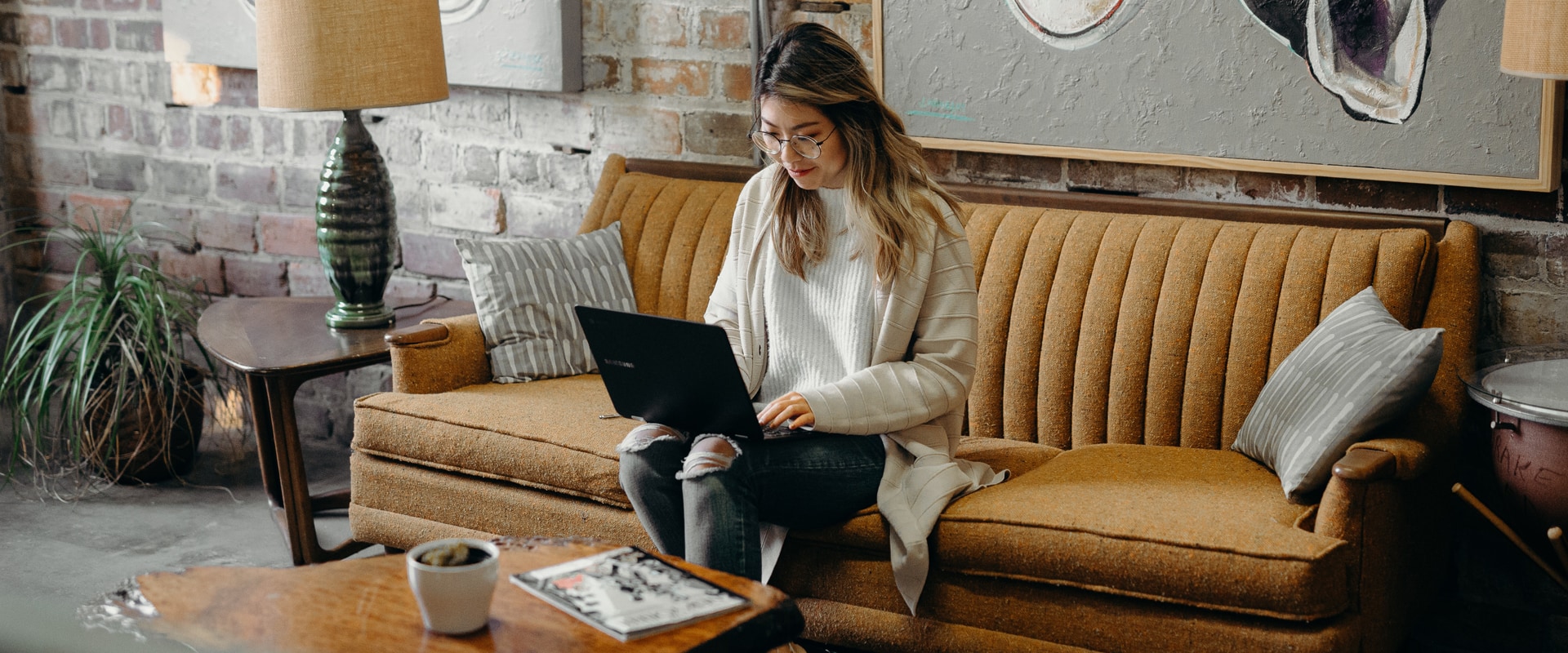 Woman sitting on couch using laptop