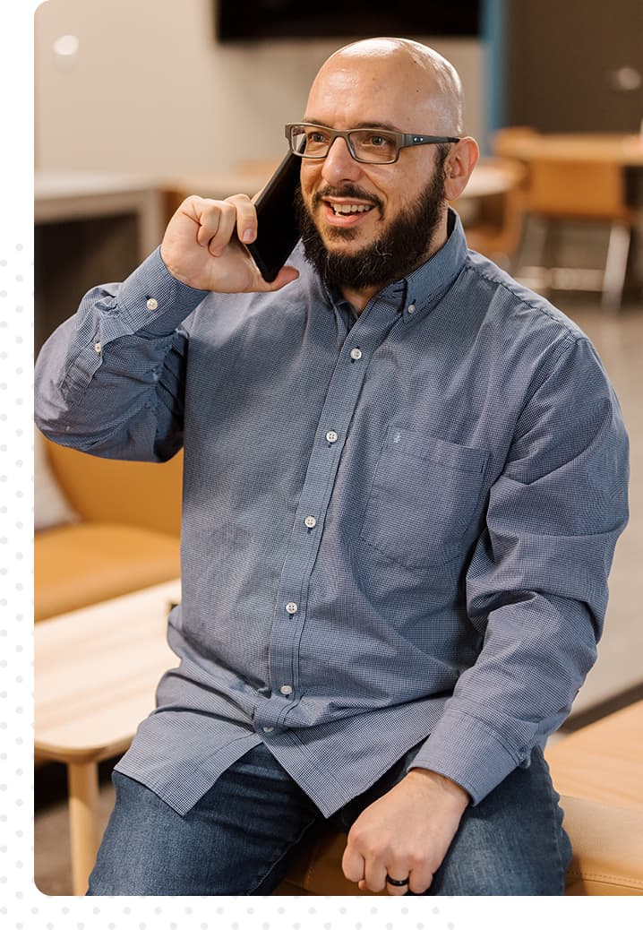 Man in a button-down shirt and glasses talking on the phone