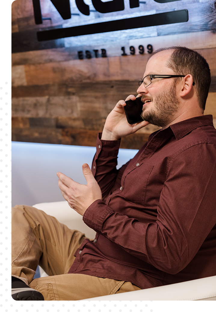 David Kraft on phone Man with glasses sitting down, talking on the phone, gesturing with his hand.