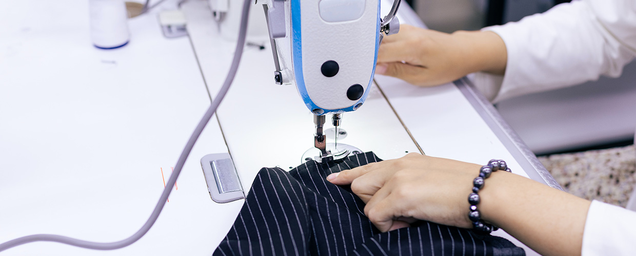 Image of a women sewing at a sewing maching.